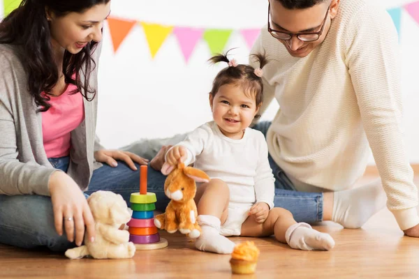 Baby girl with parents playing with toy rabbit — Stock Photo, Image