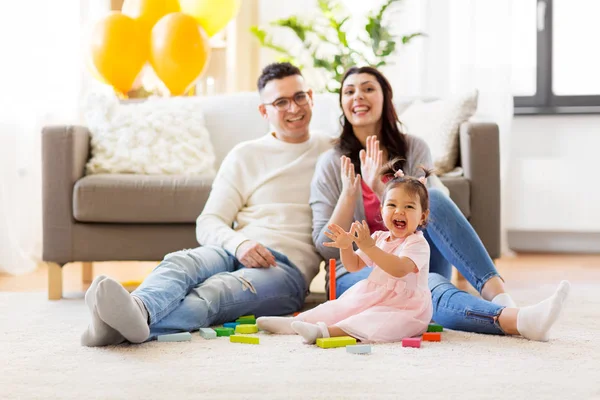 Babymeisje met ouders klappen handen thuis — Stockfoto
