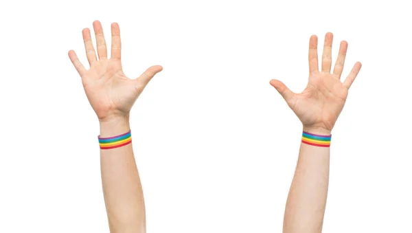 Handen met gay pride regenboog polsbandjes — Stockfoto