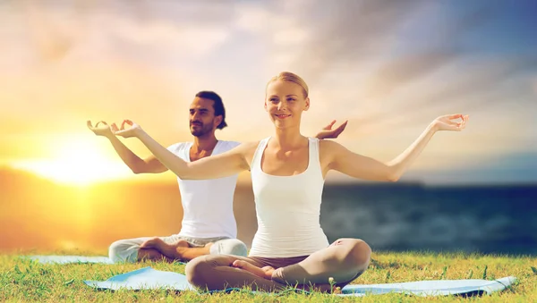 Yoga yapmak ve açık havada meditasyon mutlu çift — Stok fotoğraf