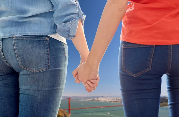 Schwules Paar hält Händchen über goldene Torbrücke — Stockfoto