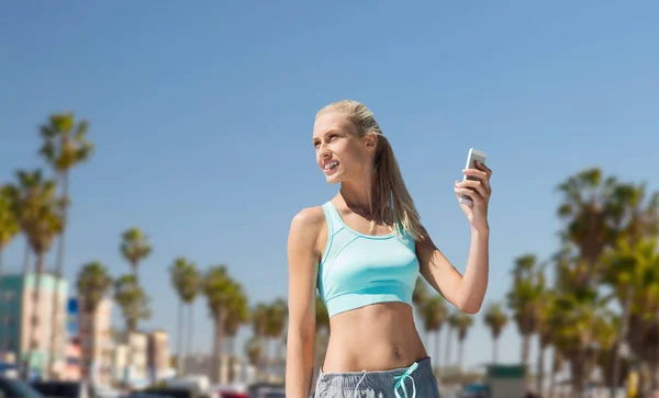Vrouw met smartphone doen sporten in los angeles — Stockfoto