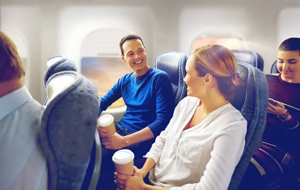 愉快的乘客与咖啡谈话在飞机上 — 图库照片