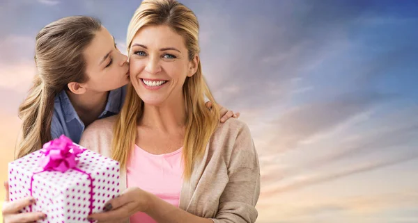 Hija besando a madre y dándole su regalo — Foto de Stock