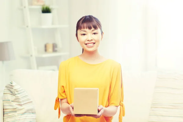 Happy asian young woman with parcel box at home — Stock Photo, Image