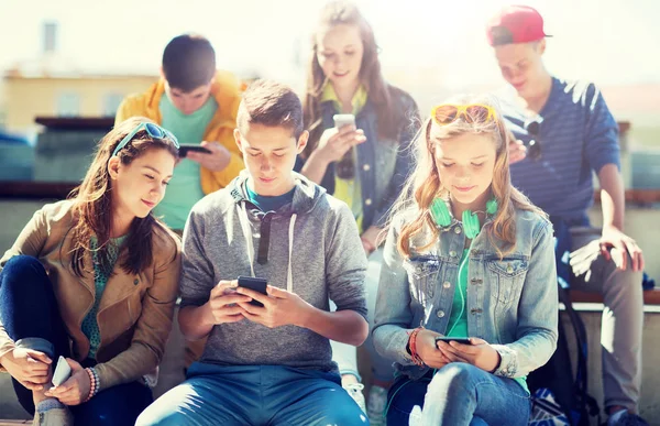 Ευτυχισμένος εφηβική τους φίλους με smartphones σε εξωτερικούς χώρους — Φωτογραφία Αρχείου