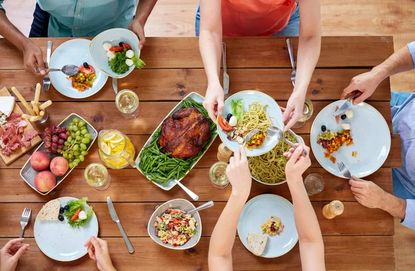 Grupo de personas que comen en la mesa con alimentos — Foto de Stock