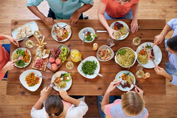 Grupp av människor som äter vid bordet med mat — Stockfoto
