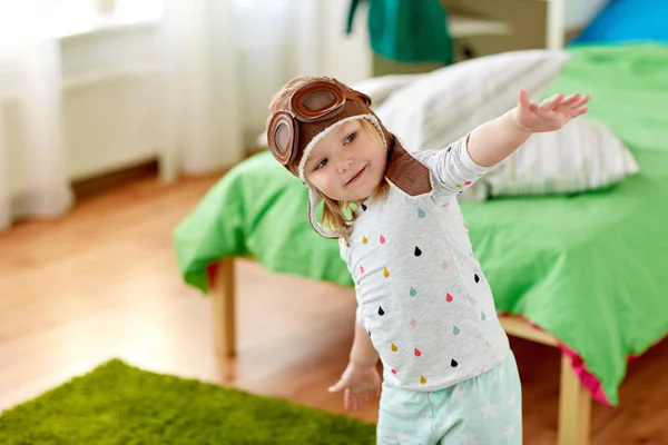 Happy little girl in pilot hat playing at home — Stock Photo, Image