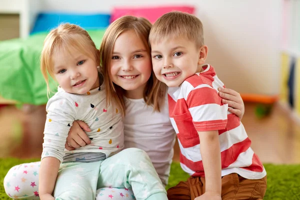 Niños pequeños y felices abrazándose en casa — Foto de Stock