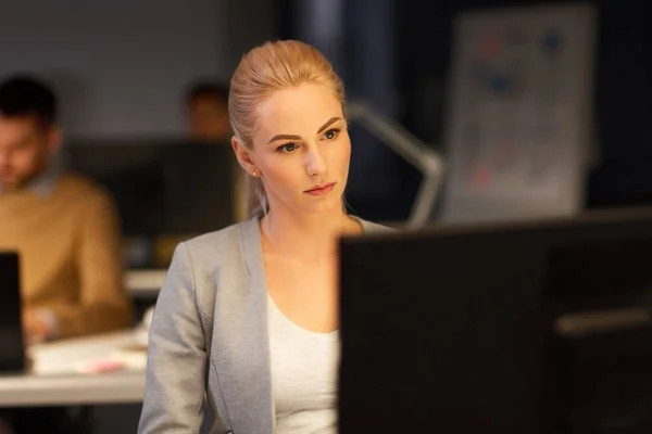 Mujer de negocios en la computadora trabajando en la oficina nocturna — Foto de Stock