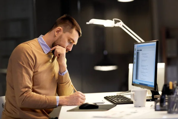 Homme avec bloc-notes travaillant sur le code au bureau de nuit — Photo