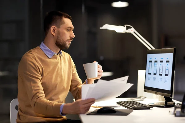 Man with papers and computer works at night office — Stock Photo, Image