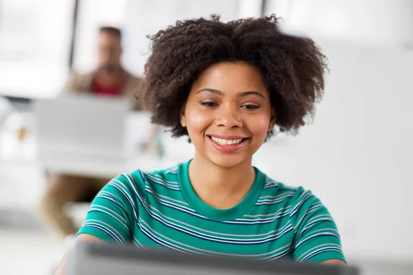 Mujer africana feliz con ordenador portátil en la oficina — Foto de Stock