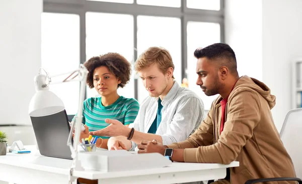 Lyckliga kreativa arbetstagare med bärbara datorer på kontor — Stockfoto