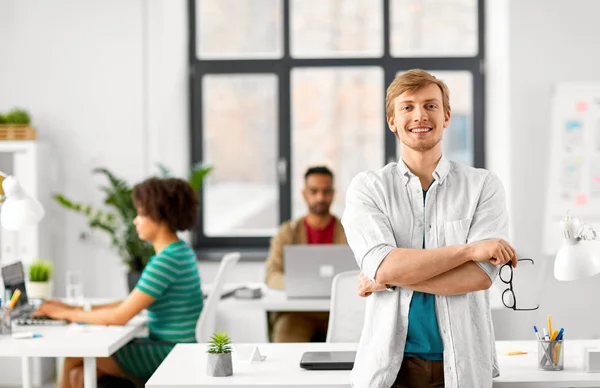 Lyckligt leende mannen med glasögon på kontor — Stockfoto