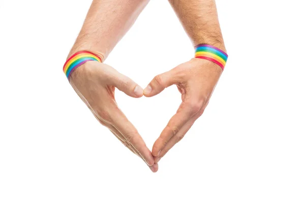 Manos masculinas con pulseras de orgullo gay mostrando el corazón — Foto de Stock