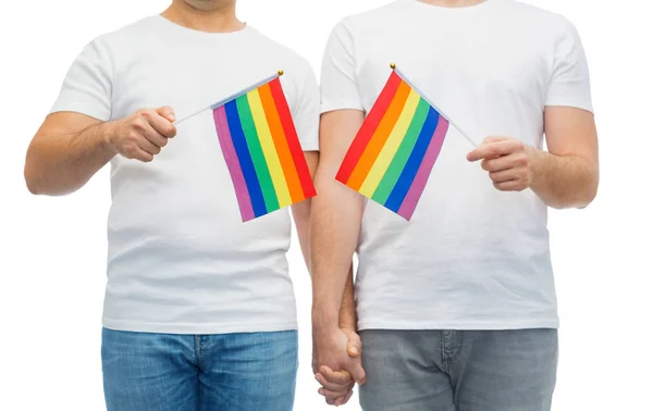 Чоловіча пара з прапорами гомосексуальної гордості тримає руки — стокове фото