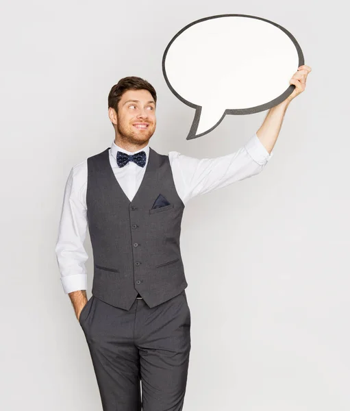 Šťastný muž v obleku drží prázdné textové bubliny nápis — Stock fotografie