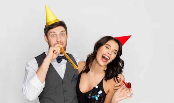 Feliz pareja con ventiladores de fiesta que se divierten — Foto de Stock