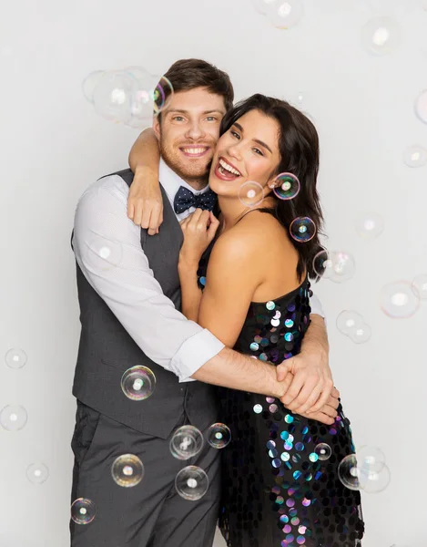 Feliz casal abraçando em bolhas de sabão na festa — Fotografia de Stock