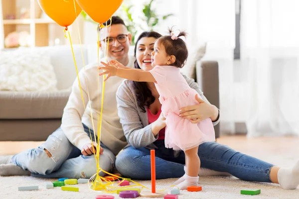 Baby girl reaching to balloons at birthday party — Stock Photo, Image