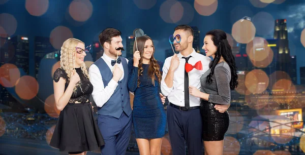 Amigos felizes com adereços de festa — Fotografia de Stock