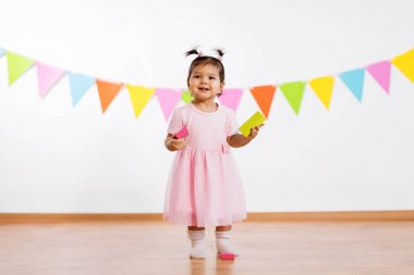 happy baby girl with toy blocks at birthday party clipart