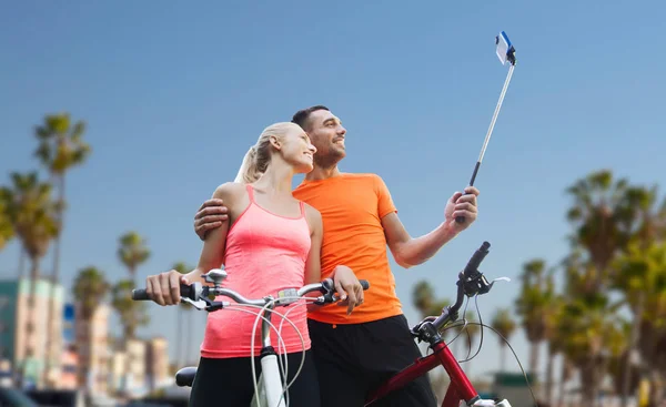 Para z rowerów i smartphone selfie trzymać — Zdjęcie stockowe