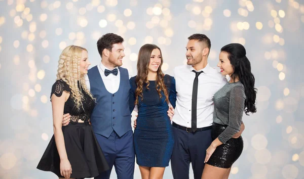 Amigos felizes em roupas de festa abraçando luzes — Fotografia de Stock