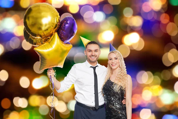 Feliz pareja con globos sobre luces de fiesta —  Fotos de Stock