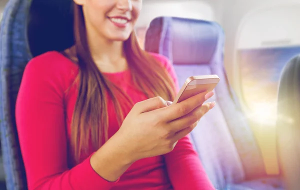 Nahaufnahme einer Frau, die mit Smartphone im Flugzeug sitzt — Stockfoto