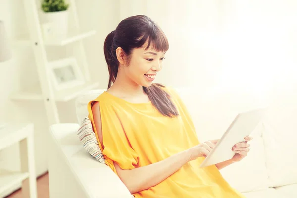 Χαρούμενος νεαρός ασιατική γυναίκα με tablet pc στο σπίτι — Φωτογραφία Αρχείου