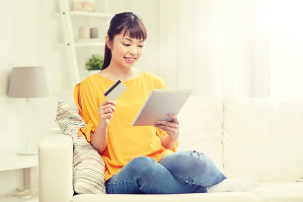 Mujer asiática feliz con la tableta PC y tarjeta de crédito — Foto de Stock