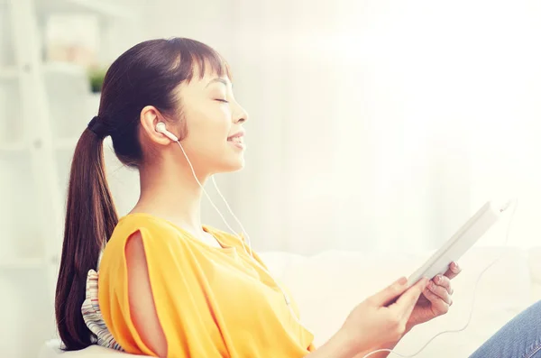 Happy asiatisk kvinna med TabletPC och hörlurar — Stockfoto