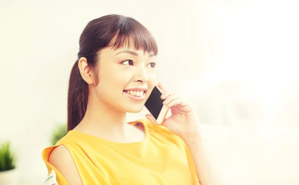 Feliz mulher asiática chamando no smartphone em casa — Fotografia de Stock