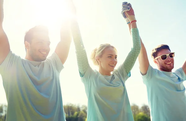 Groep gelukkig vrijwilligers buitenshuis hand in hand — Stockfoto