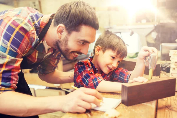 Padre e hijo con tabla de medir regla en el taller — Foto de Stock