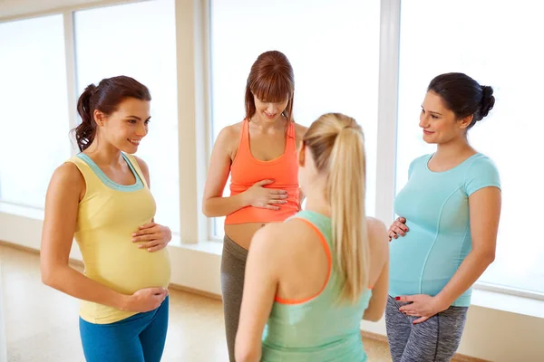 Счастливые беременные женщины разговаривают в спортзале — стоковое фото