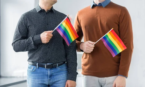 Close up de feliz casal masculino com gay orgulho bandeiras — Fotografia de Stock