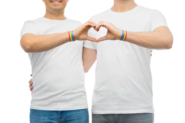 Pareja con gay orgullo arco iris pulseras y corazón — Foto de Stock