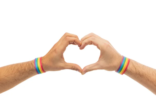 Manos masculinas con pulseras de orgullo gay mostrando el corazón — Foto de Stock