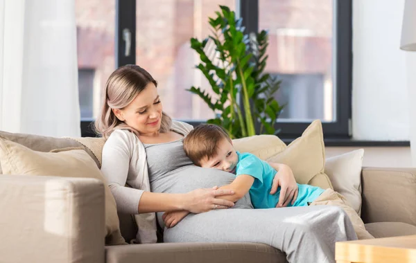 Felice madre incinta e figlio abbracciare a casa — Foto Stock