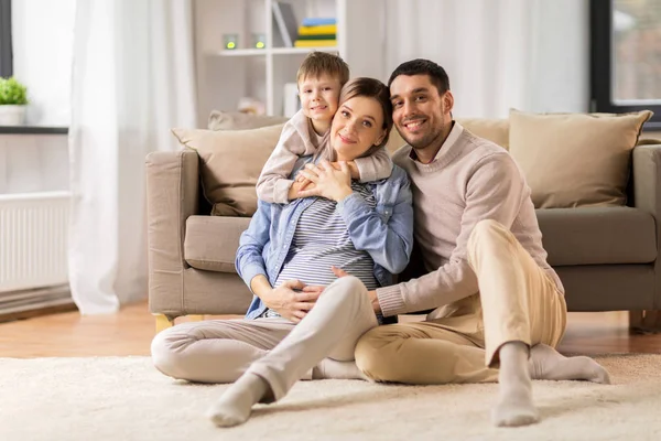 Família feliz com mãe grávida em casa — Fotografia de Stock