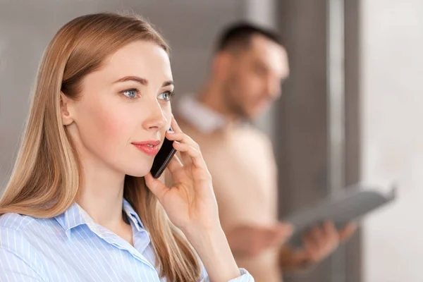 Empresária chamando no smartphone no escritório — Fotografia de Stock