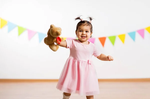 Menina feliz com ursinho de pelúcia na festa de aniversário — Fotografia de Stock