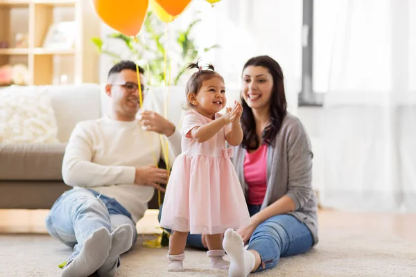 Happy babymeisje en ouders op home verjaardagsfeestje — Stockfoto