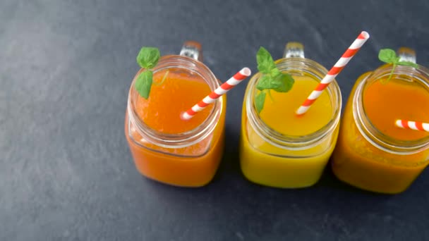 Primer plano de zumos frescos en vasos de tarro de albañil — Vídeos de Stock