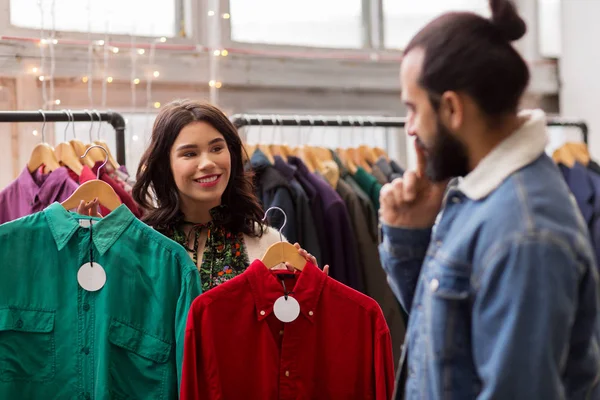 Pareja eligiendo ropa en tienda de ropa vintage — Foto de Stock