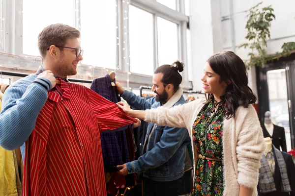 Amici che scelgono vestiti al negozio di abbigliamento vintage — Foto Stock